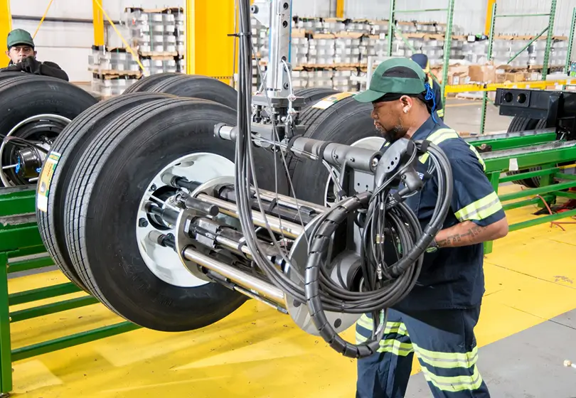 Factory worker mounting tires on the production line